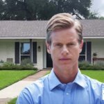 Worried Texas homeowner standing in front of house with negative equity, exploring selling options with Grandma House Buyer